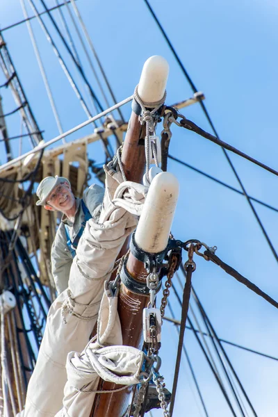 Man aan het werk op hoogte op een zeilboot mast — Stockfoto