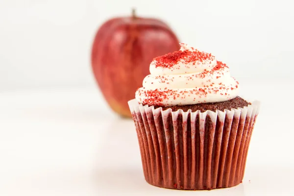 Красное яблоко против красного бархатного кекса — стоковое фото