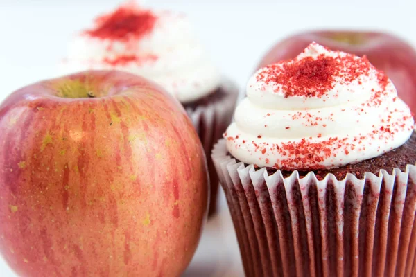 Красное яблоко против красного бархатного кекса — стоковое фото