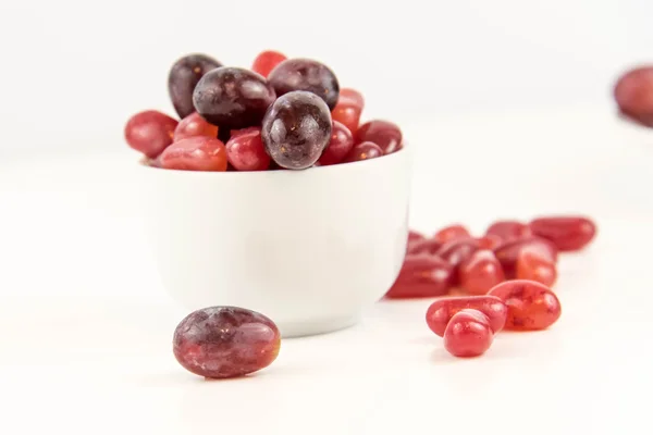 Purple grapes vs purple jelly beans — Stock Photo, Image