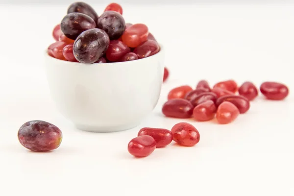 Purple grapes vs purple jelly beans — Stock Photo, Image