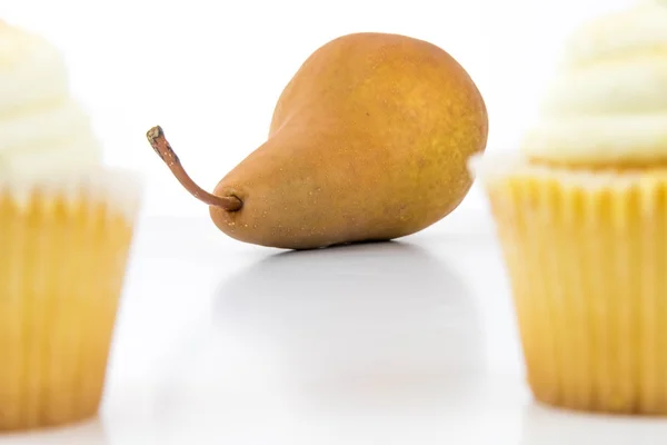 Yellow pear vs yellow cupcake — Stock Photo, Image