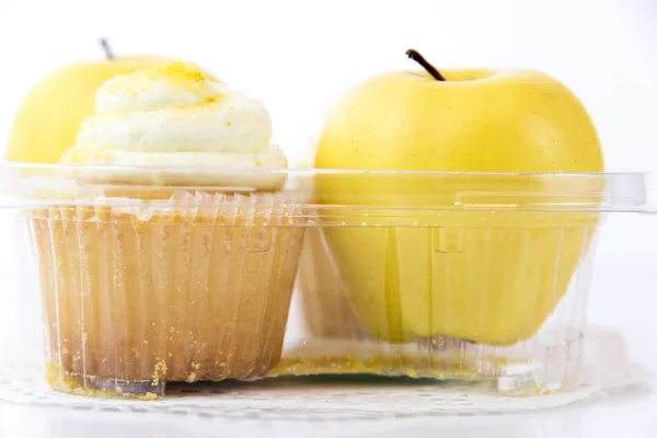 Yellow apple vs yellow cupcake — Stock Photo, Image