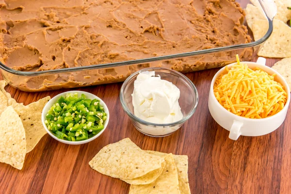 Preparation of bean dip with jalapenos, sour cream and cheddar c — Stock Photo, Image