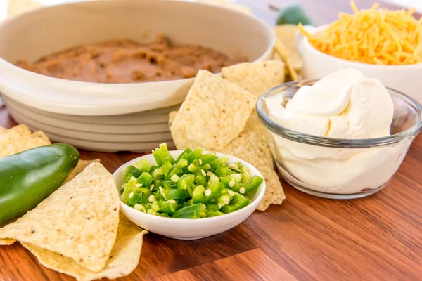 Zubereitung von Bohnen-Dip mit Jalapenos, saurer Sahne und Cheddar — Stockfoto