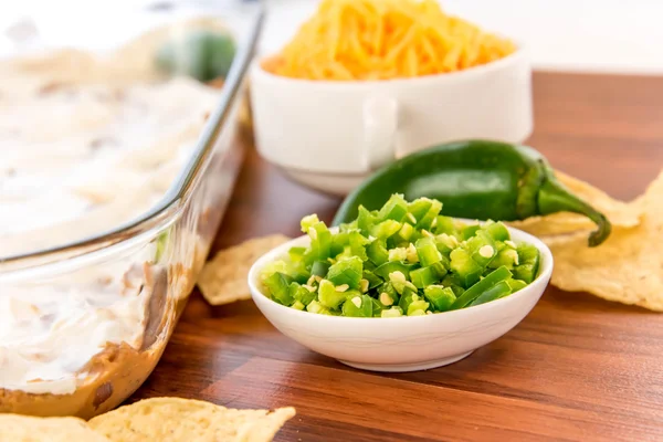 Zubereitung von Bohnen-Dip mit Jalapenos, saurer Sahne und Cheddar — Stockfoto