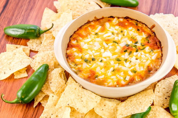 hot bean dip with jalapenos, sour cream and melted cheddar chees
