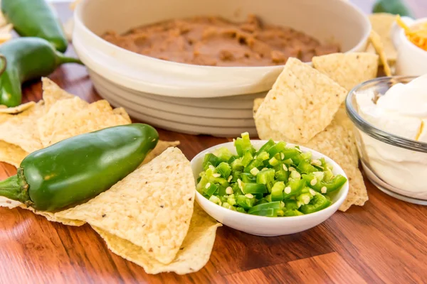 Preparación de salsa de frijol con jalapeños, crema agria y cheddar c Imagen De Stock