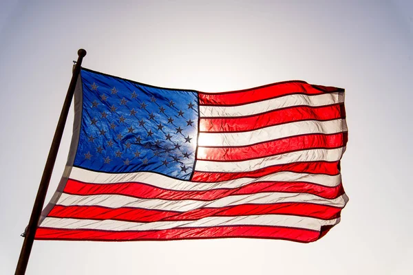 USA flag waving against a sunny blue sky — Stock Photo, Image