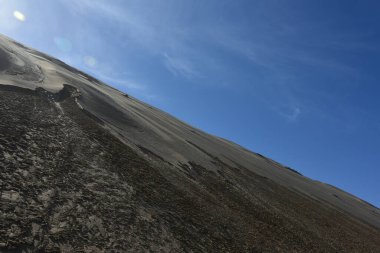 Namib 'deki mavi gökyüzüne karşı taşlaşmış bir kum tepesi