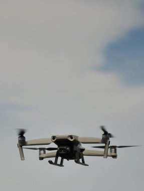 Arkasında bulutlar ve mavi gökyüzü olan bir dron.