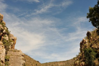 Batı Burnu Dağları 'ndaki Outeniqua Dağları' nda dramatik bulut şekilleri etrafında bir çerçeve oluşturan kayalar