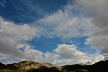 Batı Burnu Dağları dramatik bulutlarla benekli parlak mavi gökyüzü