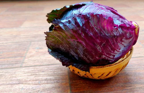 Küçük bir sepetteki taze kırmızı lahana taze yapraklı sebzeler.