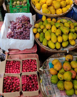 Mango, kiraz ve üzüm gibi meyveler pazarda satışta tutulur.