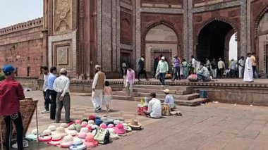 5 Mayıs 2025, Uttar Pradesh, Hindistan, yerel satıcılar Fatehpur Sikri 'nin devasa kapısında oturuyorlar, ziyaretçilere el sanatları ve şapkalar satıyorlar..