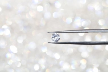 cımbız tarafından düzenlenen elmas kapatın. odakta dışında daha fazla elmas