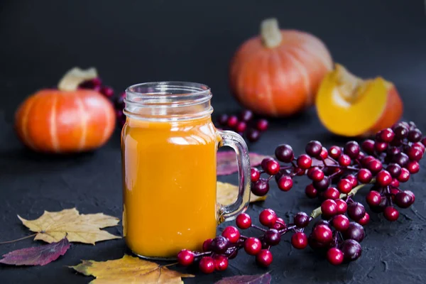 Halloween cocktail, pumpkin orange drink with spices. Dark vintage dirty background. Creative atmospheric decoration