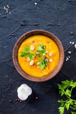 Lezzetli sağlıklı balkabağı çorbası, bitkiler ve yemek için malzemeler. Yaratıcı atmosfer dekorasyonu