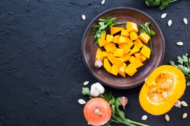 Çok güzel doğranmış balkabağı salatası, şifalı otlar ve yemek için malzemeler. Yaratıcı atmosfer dekorasyonu