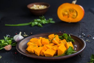 Çok güzel doğranmış balkabağı salatası, şifalı otlar ve yemek için malzemeler. Yaratıcı atmosfer dekorasyonu