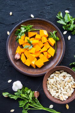 Çok güzel doğranmış balkabağı salatası, şifalı otlar ve yemek için malzemeler. Yaratıcı atmosfer dekorasyonu