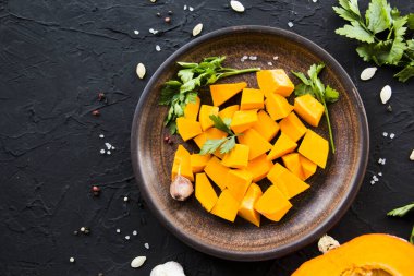 Çok güzel doğranmış balkabağı salatası, şifalı otlar ve yemek için malzemeler. Yaratıcı atmosfer dekorasyonu