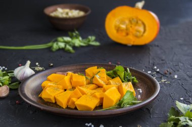 Çok güzel doğranmış balkabağı salatası, şifalı otlar ve yemek için malzemeler. Yaratıcı atmosfer dekorasyonu