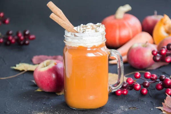 Halloween cocktail, pumpkin orange drink with spices. Dark vintage dirty background. Creative atmospheric decoration