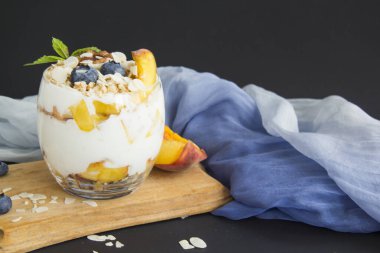 Sağlıklı yaban mersini ve beyaz arka planda bir bardakta cevizli parfe.