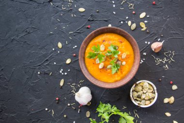 Lezzetli sağlıklı balkabağı çorbası, bitkiler ve yemek için malzemeler. Yaratıcı atmosfer dekorasyonu