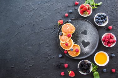 Peynirli krep, böğürtlen ve baldan oluşan sağlıklı bir kahvaltı. Yaratıcı atmosfer dekorasyonu