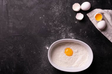 Siyah bir masada ekmek hamuru yapmak için gerekli malzemeler.