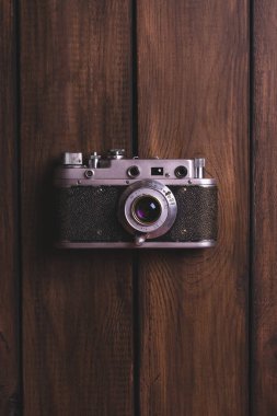 Ahşap bir masada eski bir kamera, yakın çekim, üst manzara.