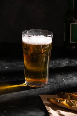 Büyük bir bardak light bira ve iki kurutulmuş balık.