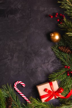 Çam dalları, oyuncaklar, şekerler ve hediye kutusuyla süslenmiş Noel arkaplanı