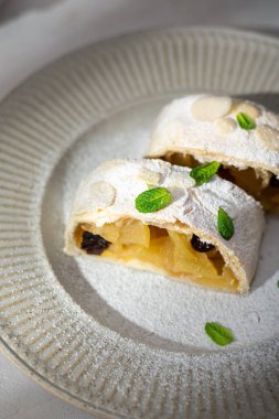 Elmalı turtayı tarçınlı ve naneli bir tabakta yakın.