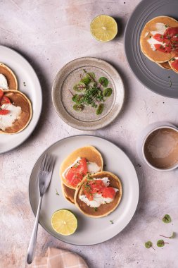 Taze pişmiş krep, somon balığı ve tabakta mikroyeşillikler.