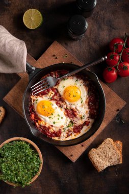 Shakshouka ve sebzelerle kahvaltı ahşap bir masada yakın plan