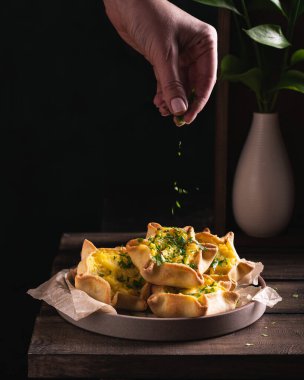 İtalyan yemeği ev yapımı makarnaya yeşillik ekleyen bir kadın.