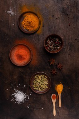 Tahta bir arka planda Paprika, biber, kardamon, tuz ve sokağa çıkma yasağı