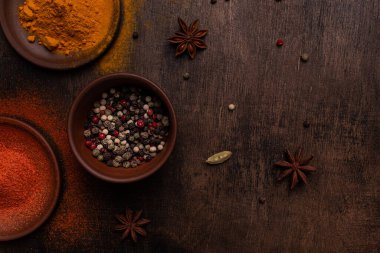 Tahta bir arka planda Paprika, biber, kardamon, tuz ve sokağa çıkma yasağı