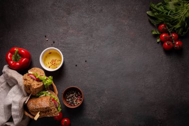 Siyah arka planda öğle yemeği için sebzeli sandviç.