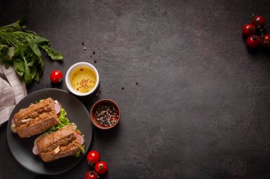 Siyah arka planda öğle yemeği için sebzeli sandviç.