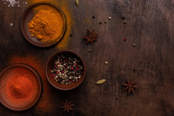 Tahta bir arka planda Paprika, biber, kardamon, tuz ve sokağa çıkma yasağı