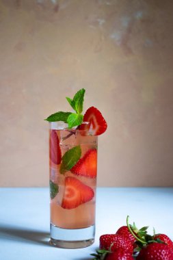 Beyaz arka planda naneli üç bardak çilekli mojito.