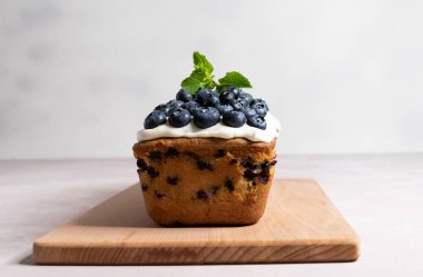 Böğürtlenli kek ve krem peynirli ganache. Gri arka plandaki tahtanın üzerinde.