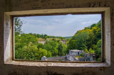 Pencerenin yeşil doğası arasında güzel bir kanyon manzarası, elektrik santralinin eski bir kalıntısı, Buky Canyon Ukrayna