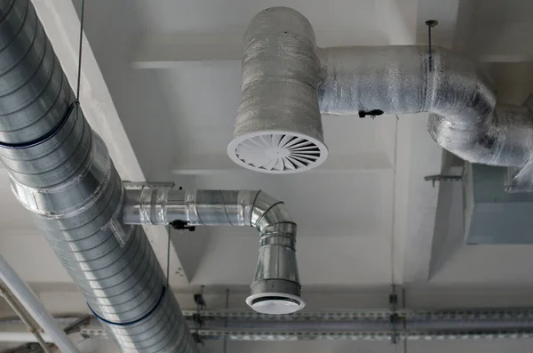 Air duct, air conditioner pipe and fire sprinkler system on white ceiling wall. Building interior. Air flow and ventilation system. Interior architecture concept.
