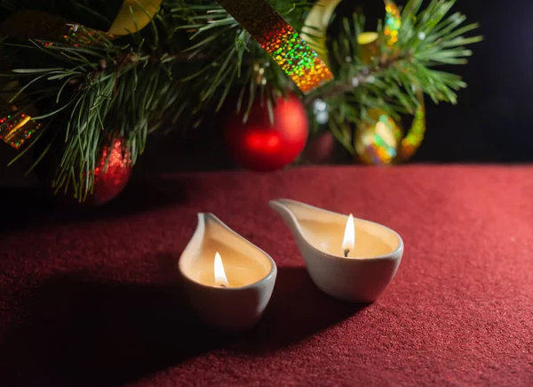 两根蜡烛在夜里燃着 用红球和金箔带模糊的圣诞树背景 复制空间 — 图库照片